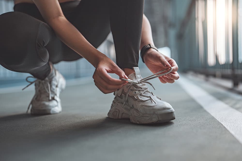 Person tying an athletic shoe. Person tying an athletic shoe.