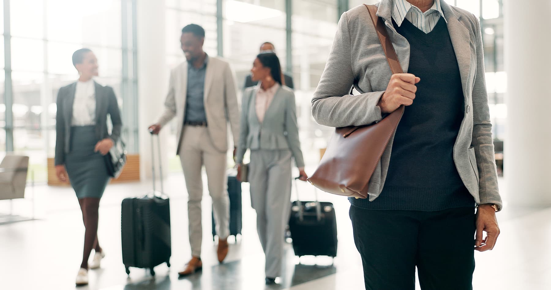 business travelers with carryon luggage walking thru well lit airport business travelers with carryon luggage walking thru well lit airport