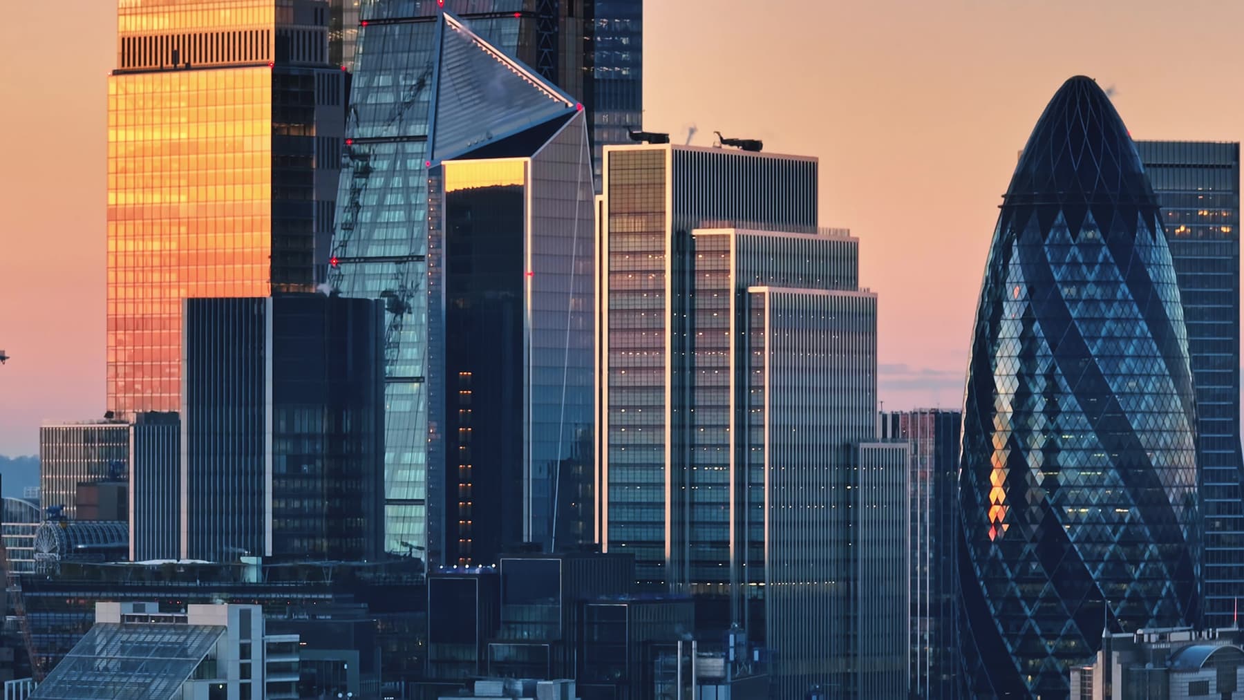 Modern glass skyscrapers reflecting sunset light during golden hour in London's financial district Modern glass skyscrapers reflecting sunset light during golden hour in London's financial district